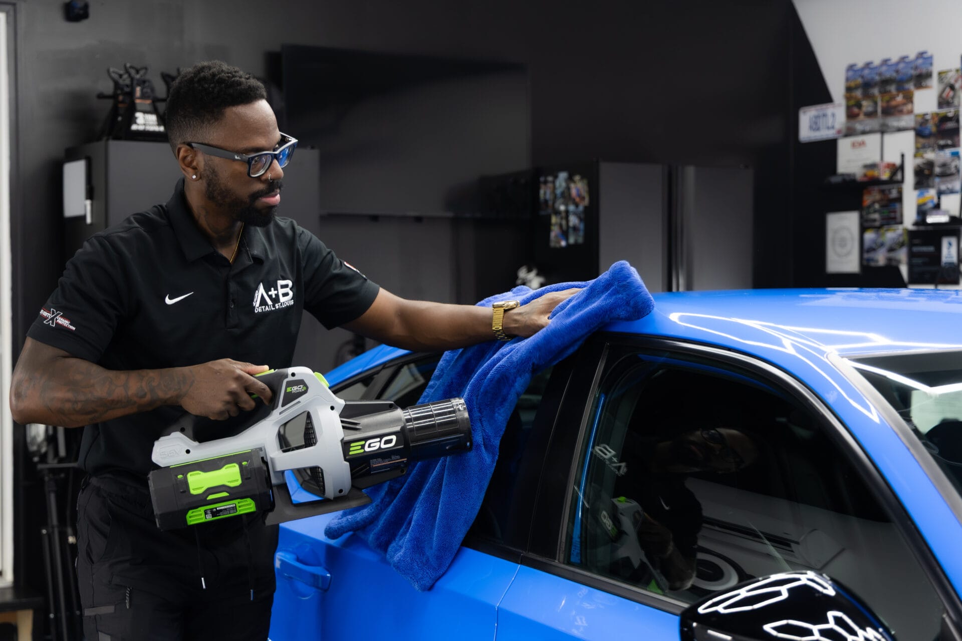 Detailing technician working on blue car at A+B Detail St.Louis